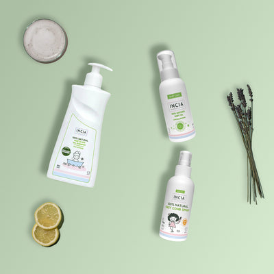 Flat lay of the INCIA Baby Bath Time Set on a sage green background with lavender, lemon slices and a bowl of foam