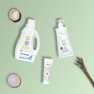 Flat lay of the INCIA Eczema-Prone Skin Wash & Care Set on a sage green background with coconut, lavender and a bowl of foam