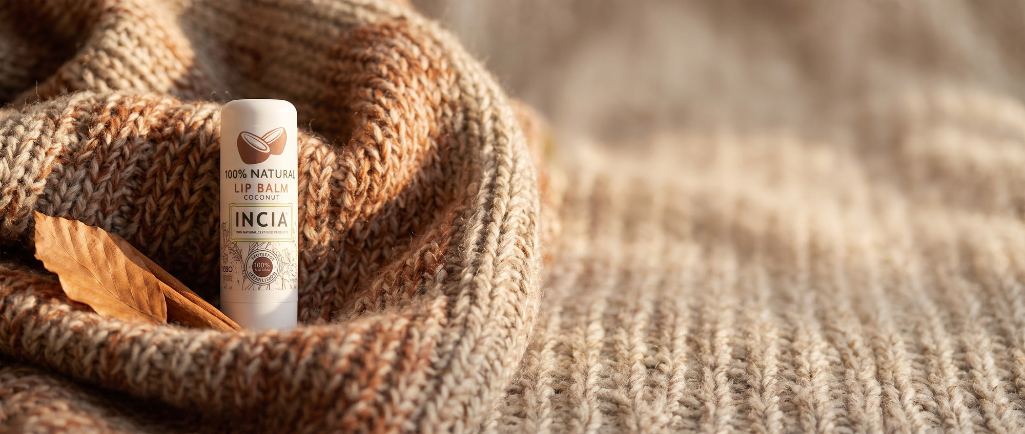 INCIA natural lip balm nestled in a knitted wool blanket