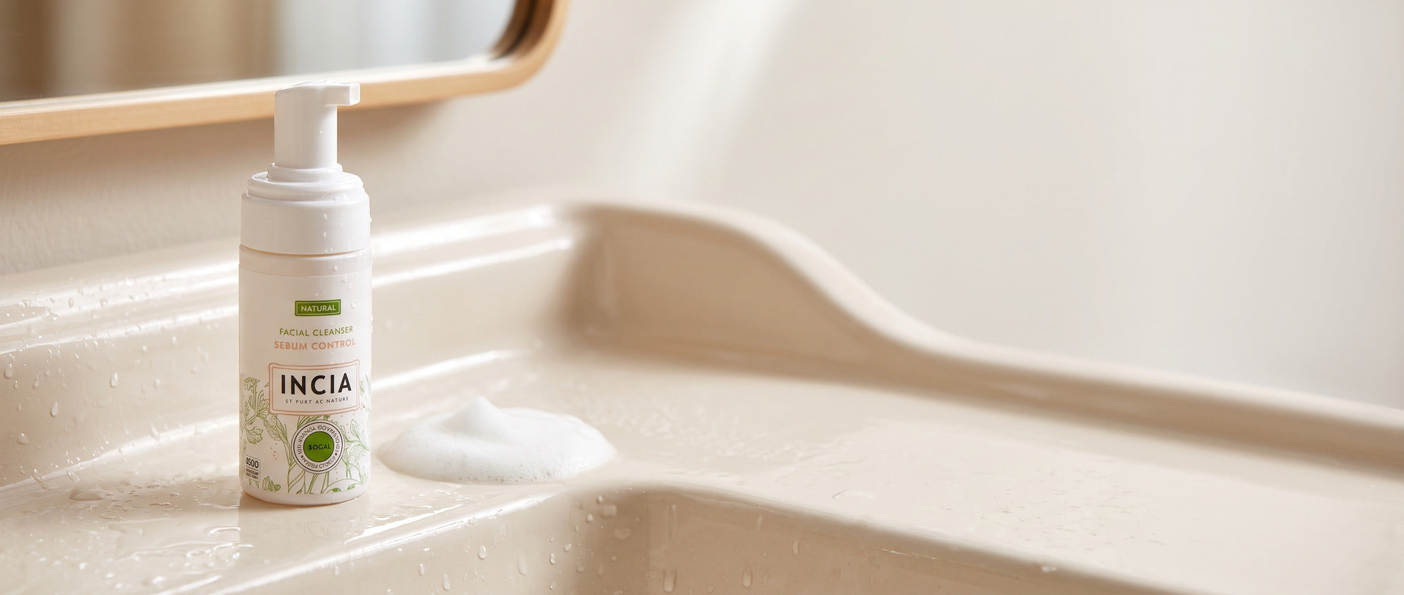 INCIA foaming facial cleanser on a wet ceramic washbasin